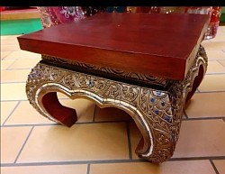 Cette élégante table sellette venue d’Inde. Son plateau en bois rouge et ses pieds finement décorés de motifs dorés et pierres bleues en font une pièce aussi décorative que fonctionnelle.  - Dimensions : H 23 cm × L 13 cm   - Matériau : bois sculpté et décoré à la main   - Prix : 80,00 € TTC