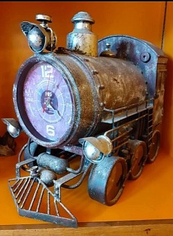 Ce train d’horloges au look vintage industriel est bien plus qu’un simple objet déco : c’est une pièce maîtresse qui attire tous les regards. Fabriqué en métal avec une finition vieillie, il évoque l’élégance du passé tout en offrant une fonctionnalité moderne.  🕰️ Caractéristiques   - 7 cadrans pour suivre différents fuseaux horaires ou créer une ambiance personnalisée   - Peut être fixé au mur ou posé sur un meuble   - Compartiment de rangement intérieur pratique et discret   - Détails soignés : roues, tuyauterie, cheminée, et finitions patinée  - Hauteur : 50 cm   - Largeur : 51 cm   - Profondeur : 30 cm    Prix : 400,00 €
