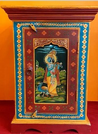 Ce meuble en bois de manguier, originaire du Rajasthan. Entièrement peint à la main, il représente la divine union de Krishna et Radha, symbole d’amour spirituel et d’harmonie.  Dimensions : H 70 cm – L45 cm – Profondeur 33 cm