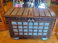 Cette superbe malle en bois ancien, aux finitions artisanales et aux teintes contrastées, évoque les voyages lointains.  L 115 cm ·  H 80 cm   Détail : Petite trappe intérieure pour rangement discret.