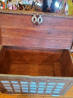 Malle des Indes –  Son design raffiné mêle tradition et caractère, avec une petite trappe intérieure qui ajoute une touche de mystère et de fonctionnalité.   Détail : Petite trappe intérieure pour rangement discret