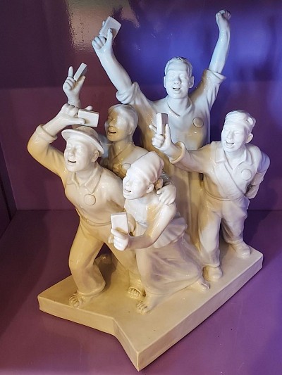 Sculpture expressive   Cette pièce unique en porcelaine blanche incarne l’élan collectif et l’énergie du peuple chinois à travers six personnages en mouvement, chacun porteur d’un symbole fort : livre, paix, expression.   Hauteur 58 cm × Largeur 43 cm    Prix : 400,00 €