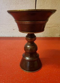 Tibétaine – Tradition & Élégance  mystique de l’Himalaya avec cette lampe à huile tibétaine au charme ancien.  Dimensions : Longueur 18 cm × Largeur 17 cm   Prix : 30,00 €  Fabriquée en métal patiné,