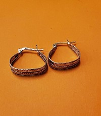 Ces boucles d’oreilles créoles en finition argentée offrent un style classique revisité.