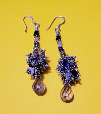 Un tissage de perles colorées, une cascade argentée, et au bout… une larme cristalline. Ces boucles d’oreilles  mêlent esprit bohème et élégance vibrante.