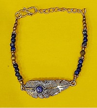 Plume dorée et perles de lapis-lazuli d'un bleu mystique